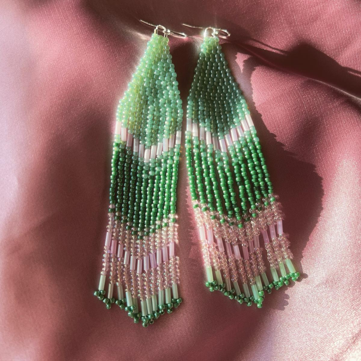 green beaded earrings on pink cloth