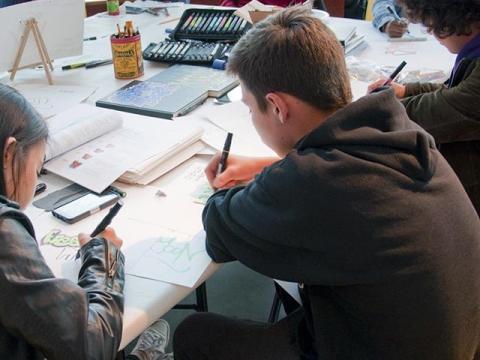 Teens drawing at table